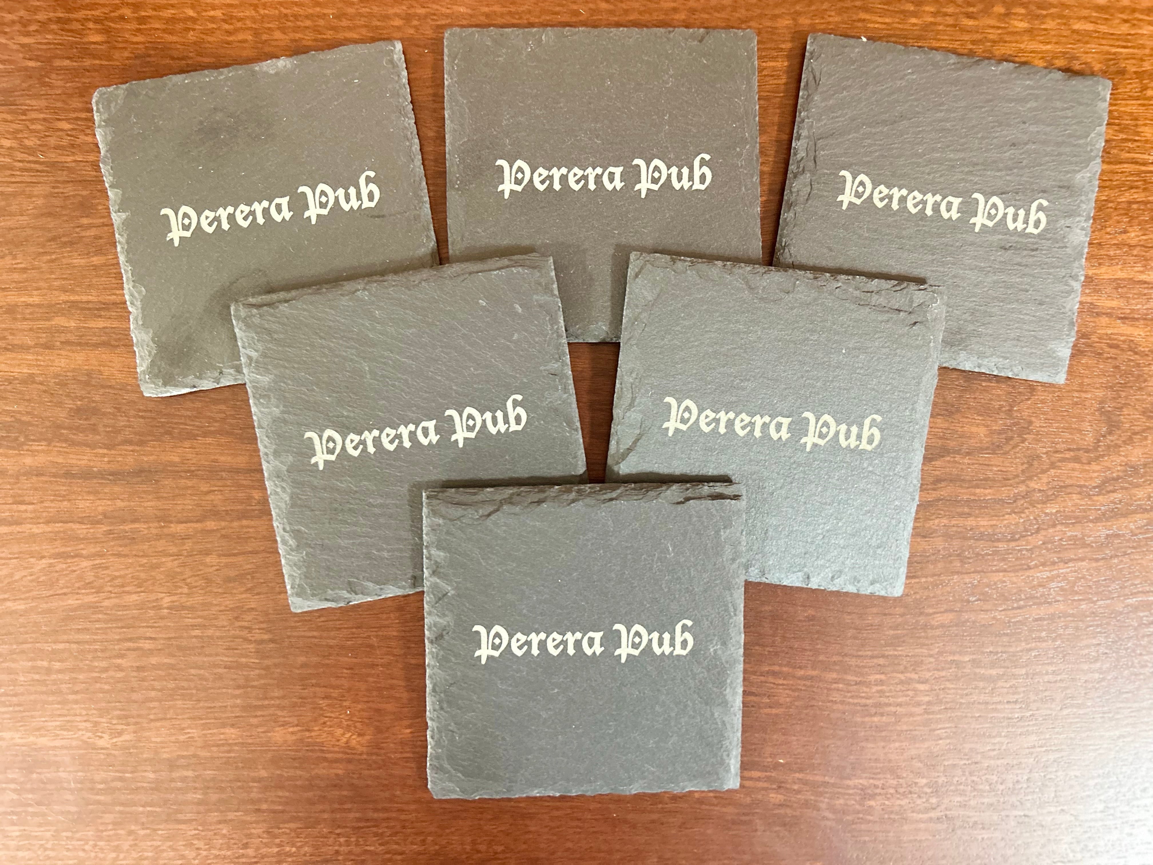 Custom engraved slate coasters with personalized pub name, ideal for outdoor patio and garden bar use.